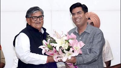 Mayor Saurabh Joshi offers a bouquet to UT administrator Gulab Chand Kataria at the special House meet on Saturday. (HT Photo)