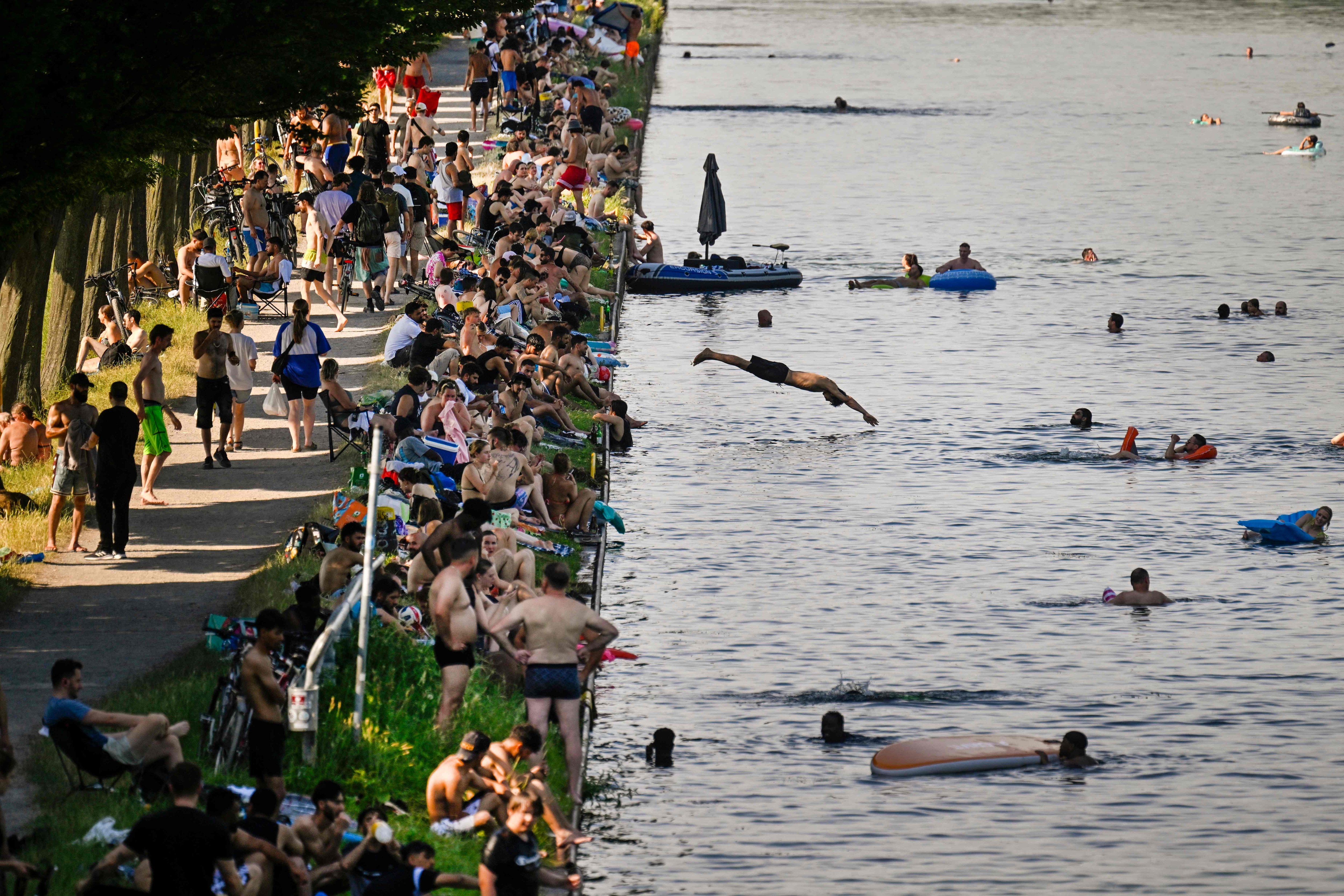 People sit at the side of a canal in Dortmund, western Germany, during a heatwave in Europe. (AFP) People sit at the side of a canal in Dortmund, western Germany, during a heatwave in Europe. (AFP)