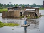 A man uses a makeshift raft to travel through floodwaters, in Morigaon district, Assam.