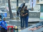 People walk through the Rain at Bandra Bandstand, in Mumbai. 
