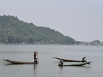 Labourers from the Jammu and Kashmir Lakes and Waterways Development Authority remove weeds from the waters of Dal Lake on a summer hot day, in Srinagar on Monday. (Basit Zargar)