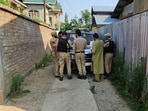 Police standing outside the house of PDP district president, Baramulla, Mohammad Rafique Rather, on Tuesday. (HT Photo)