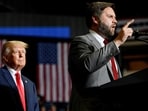 Donald Trump listens as JD Vance speaks during a rally.