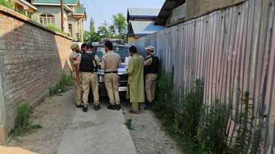 Police standing outside the house of PDP district president, Baramulla, Mohammad Rafique Rather, on Tuesday. (HT Photo)