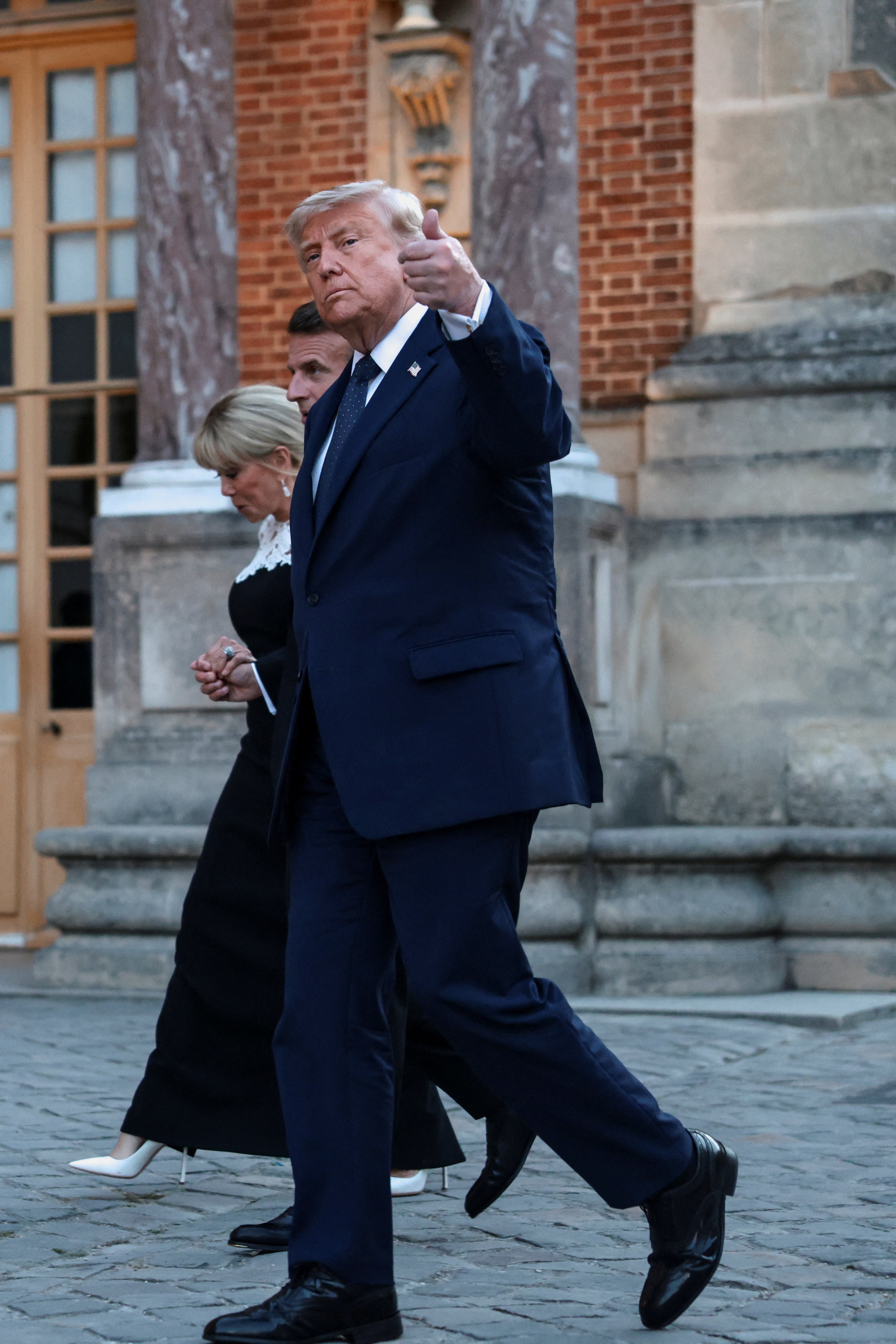 US President Donald Trump gives a thumbs up as he walks with French President Emmanuel Macron and his wife Brigitte Macron on June 17, 2026 (REUTERS)