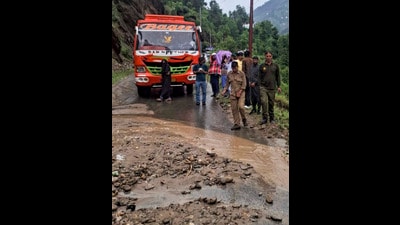A stranded bus and local commuters wait along a damaged road after heavy rainfall triggered flash floods, at Gandoh in Doda district of Jammu and Kashmir, on Wednesday. (PTI)