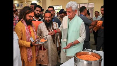 Jammu and Kashmir Lt. Governor Manoj Sinha serves food to a pilgrim during his visit to the Bhagwati Nagar base camp to review arrangements for pilgrims ahead of the annual Amarnath Yatra in Jammu on Wednesday. (PTI) Jammu and Kashmir Lt. Governor Manoj Sinha serves food to a pilgrim during his visit to the Bhagwati Nagar base camp to review arrangements for pilgrims ahead of the annual Amarnath Yatra in Jammu on Wednesday. (PTI)
