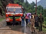 A stranded bus and local commuters wait along a damaged road after heavy rainfall triggered flash floods, at Gandoh in Doda district of Jammu and Kashmir, on Wednesday. (PTI)