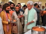Jammu and Kashmir Lt. Governor Manoj Sinha serves food to a pilgrim during his visit to the Bhagwati Nagar base camp to review arrangements for pilgrims ahead of the annual Amarnath Yatra in Jammu on Wednesday. (PTI)