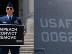 Maj. Gen. Jason Watson of the US Air Force holding a poster calling for Trump arrest at the Capitol (L) and a US Air Force branding seen on an aircraft.