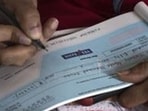 Mumbai, India - March 6, 2020: A woman fills up cheque to withdraw her money from Yes Bank branch at Fort in Mumbai, India, on Friday, March 6, 2020. (Photo by Pratik Chorge/Hindustan Times) (Pratik Chorge/HT Photo)