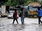 Weather, rain highlights: Pedestrians wade through rain water flooded road at Nerul MIDC during heavy rains, in Navi Mumbai.