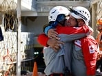 Rescue workers hug themselves after pulling out survivor Hernan Alberto Gil, who was trapped for over a week following June 24 earthquakes, from a collapsed mall in La Guaira, Venezuela, July 2, 2026,