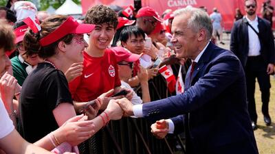 Canada Prime Minister Mark Carney greets attendees as he arrives for the Canada Day ceremony at LeBreton Flats in Ottawa, on Wednesday. (AP)