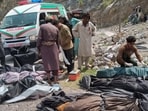 Rescue workers and volunteers cover bodies after recovering them after an overcrowded passenger bus plunged from a highway into a rocky ravine, in Dana Sar, a remote area near the border of Balochistan and Khyber Pakhtunkhwa provinces, in southwestern Pakistan,