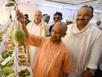 Chief minister Yogi Adityanath shows a large mango during the inauguration of UP Aam Mahotsav organised at Indira Gandhi Pratishthan in Lucknow on Friday. (Deepak Gupta/HT)