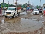 Commuters wade through waterlogged and potholes-ridden roads on Elevated Road near Jagraon Bridge in Ludhiana on Thursday. (Gurpreet Singh/HT)