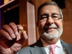 FILE PHOTO: Sanjay Mehrotra, CEO of Micron Technology Inc., shows a  chip on the floor at the New York Stock Exchange (NYSE) in New York City, U.S., April 26, 2024.  REUTERS/Brendan McDermid/File Photo