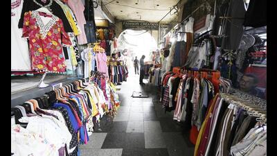 Pedestrian walkways occupied by clothes vendors in Hazratganj (below), leaving little space oom to walk, and (above) the actual space available for walking. (Deepak Gupta/HT Photo)
