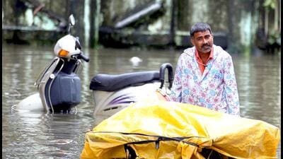 Vegetable-vendor-walks-through-flooded-water-in-BPT-colony-at-Wadala-during-heavy-rain-in-Mumbai
