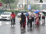 Commuters amid drizzle at Azad Pur area in North Delhi on Saturday. (Hindustan Times)