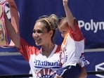 Competitive eater Miki Sudo gives holds cheers with the fans after winning the women's 2026 Nathan's Famous Fourth of July hot dog eating contest at Coney Island in the Brooklyn borough of New York, Saturday, July 4, 2026. (AP Photo/Anna Connors)