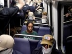 A commuter sits as members of the group Patriot Front ride the metro on the 250th anniversary of U.S. independence on the Fourth of July in Washington, D.C., U.S., July 4, 2026. REUTERS/Cheney Orr    TPX IMAGES OF THE DAY