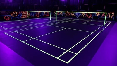Neon badminton swaps traditional courts for UV lights, fluorescent shuttlecocks and glowing court lines.