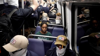 A commuter sits as members of the group Patriot Front ride the metro on the 250th anniversary of U.S. independence on the Fourth of July in Washington, D.C., U.S., July 4, 2026. REUTERS/Cheney Orr    TPX IMAGES OF THE DAY (REUTERS)