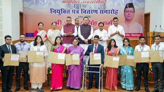 Uttarakhand Chief Minister Pushkar Singh Dhami poses for a group photo as he hands over appointment letters to the newly selected officers at the Chief Servant's Residence, in Dehradun on Friday. (@pushkardhami)