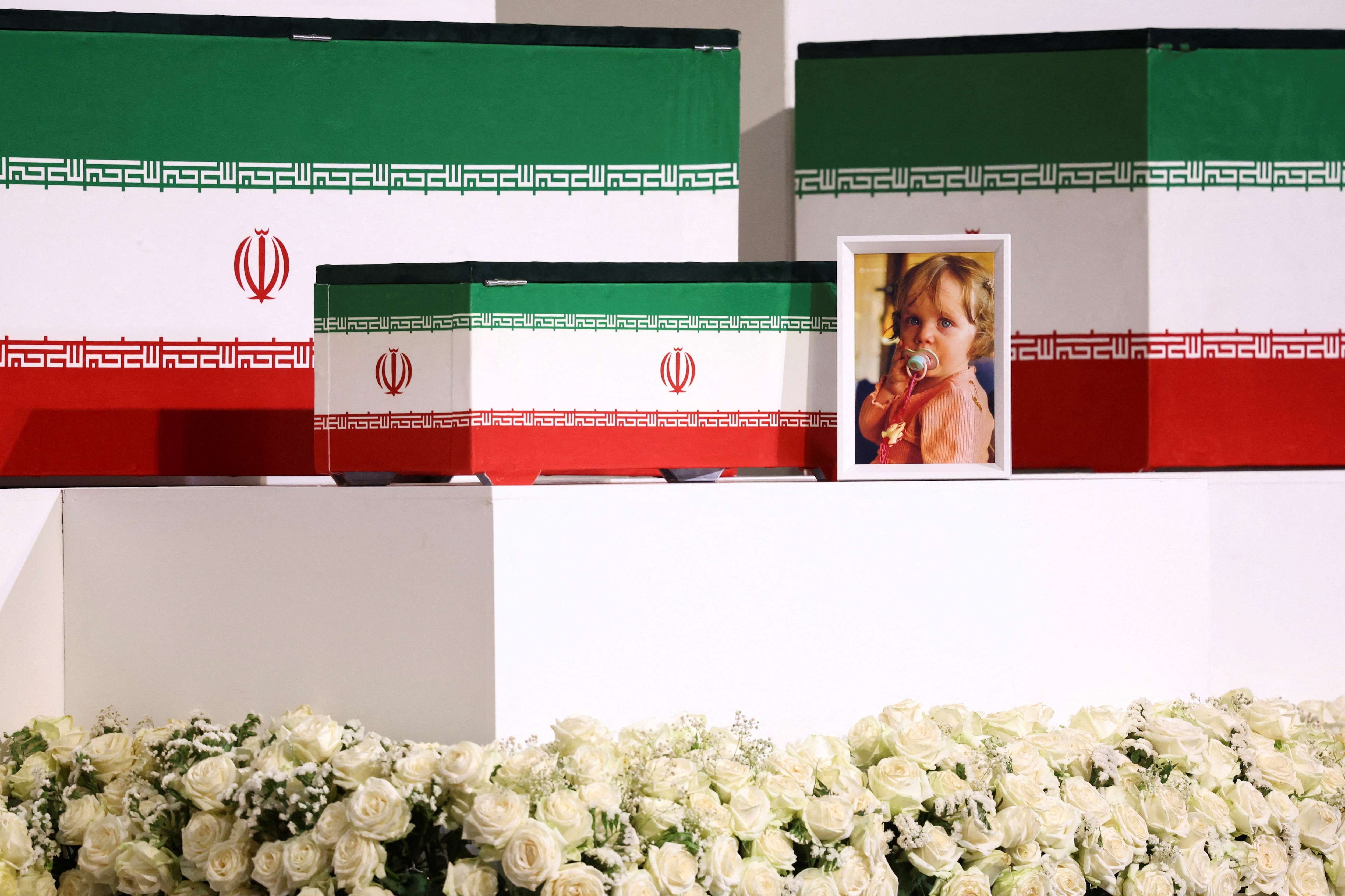 A picture of Zahra Mohammadi Golpayegani, granddaughter of Iran's late Supreme Leader Ayatollah Ali Khamenei, is displayed near the coffins of Khamenei and his family members (REUTERS)