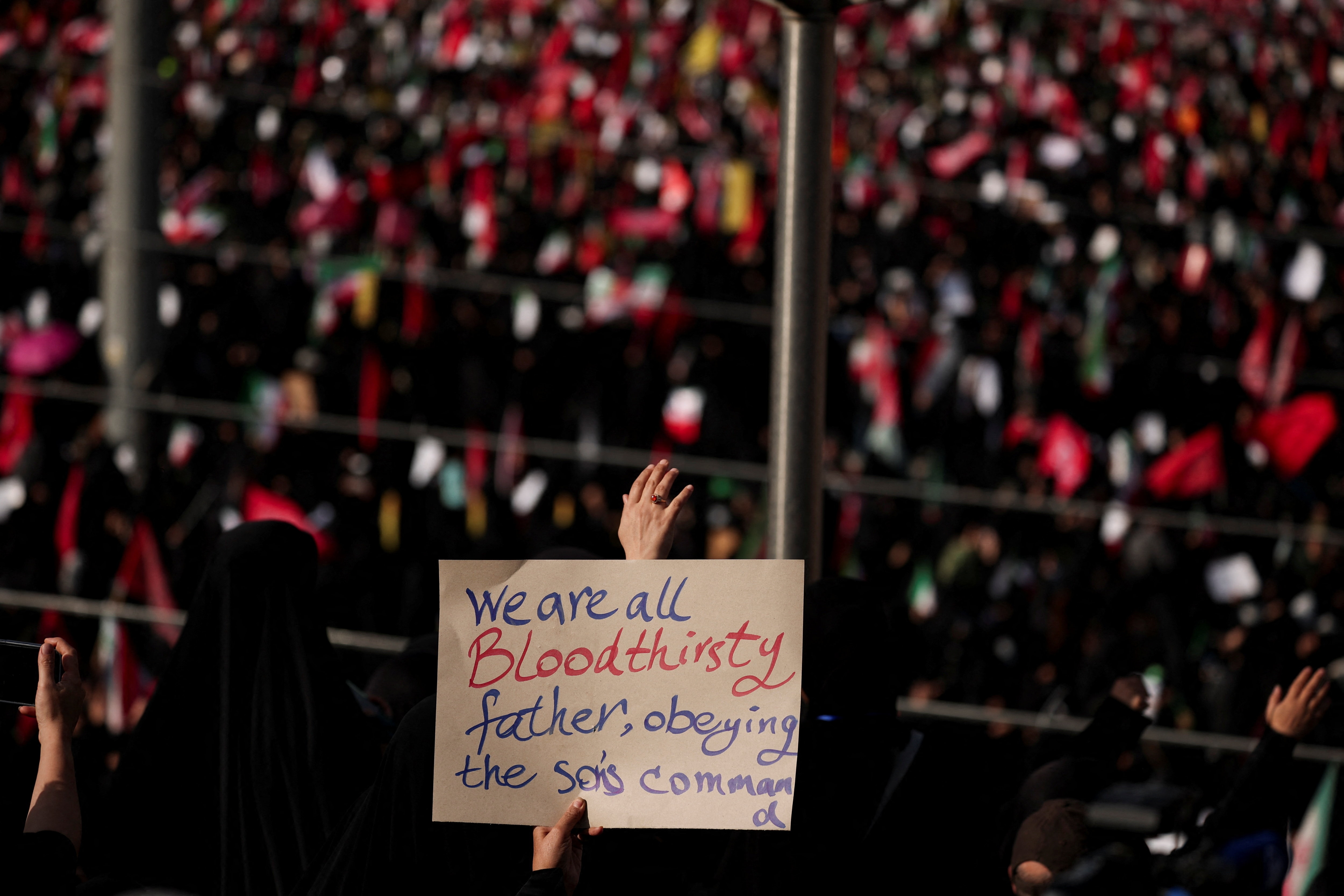 A woman holds a sign as mourners gather during a public farewell ceremony to pay their respects to late Supreme Leader Ayatollah Ali Khamenei at the Imam Khomeini Grand Mosalla, in Tehran, July 4 (REUTERS)