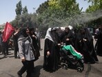 Iran US war update LIVE: People cool themselves under a water sprinkler as they attend a public farewell ceremony to pay their respects to the late Supreme Leader Ayatollah Ali Khamenei.