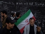 People stand next to a wall with slogans written by mourners, during a public farewell ceremony to pay their respects to late Supreme Leader Ayatollah Ali Khamenei, in Tehran, Iran July 4, 2026. 
