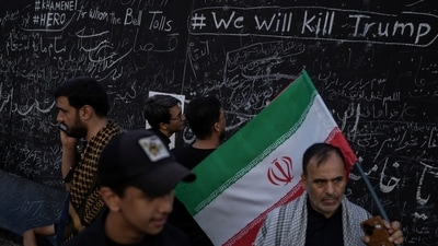 People stand next to a wall with slogans written by mourners, during a public farewell ceremony to pay their respects to late Supreme Leader Ayatollah Ali Khamenei, in Tehran, Iran July 4, 2026. (REUTERS)