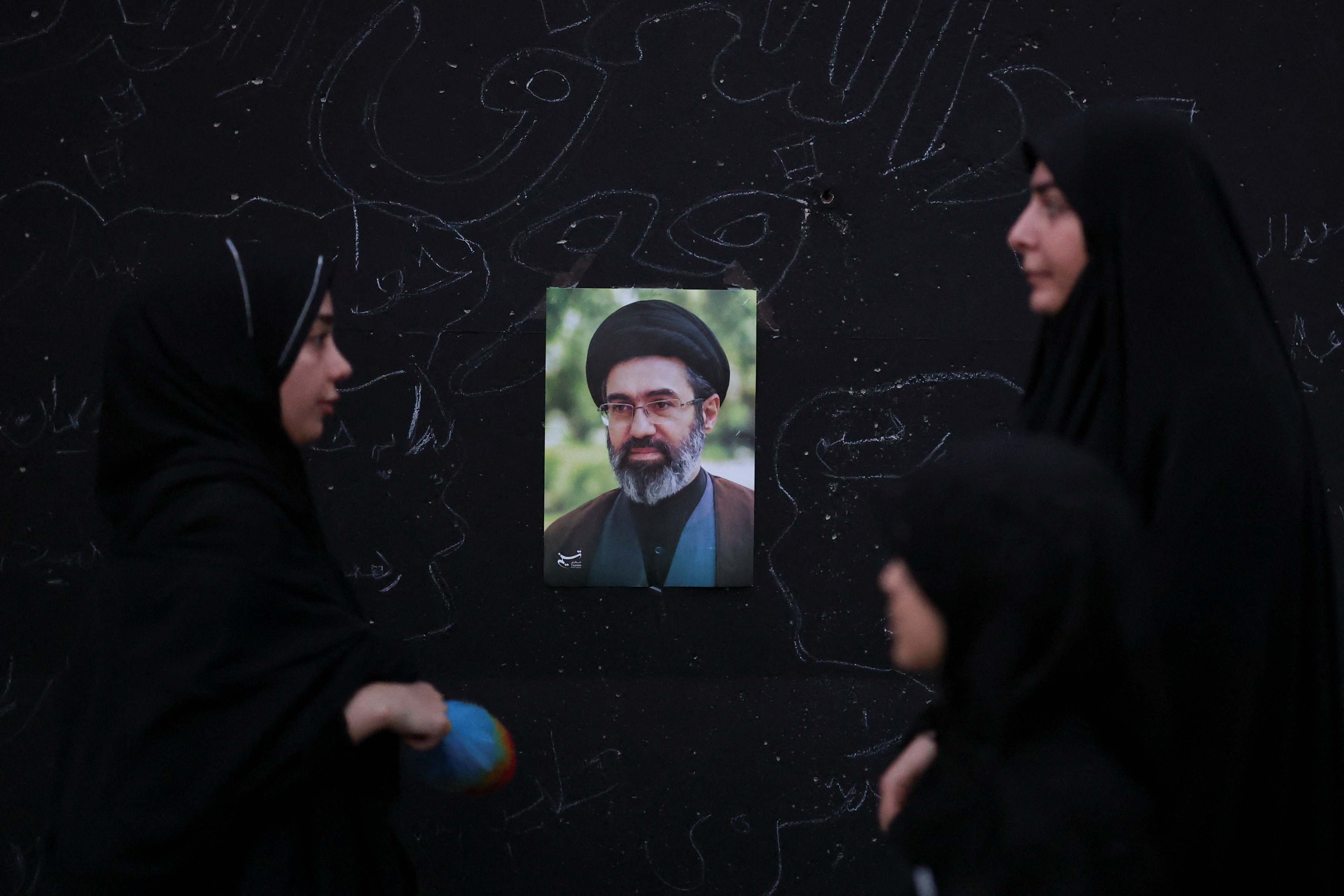 Women stand in front of a picture of Iran's Supreme Leader Mojtaba Khamenei on the day of a public farewell ceremony to pay their respects to late Supreme Leader Ayatollah Ali Khamenei, who was killed on February 28 in Israeli and US airstrikes, at the Imam Khomeini Grand Mosalla, in Tehran. (Reuters Photo)