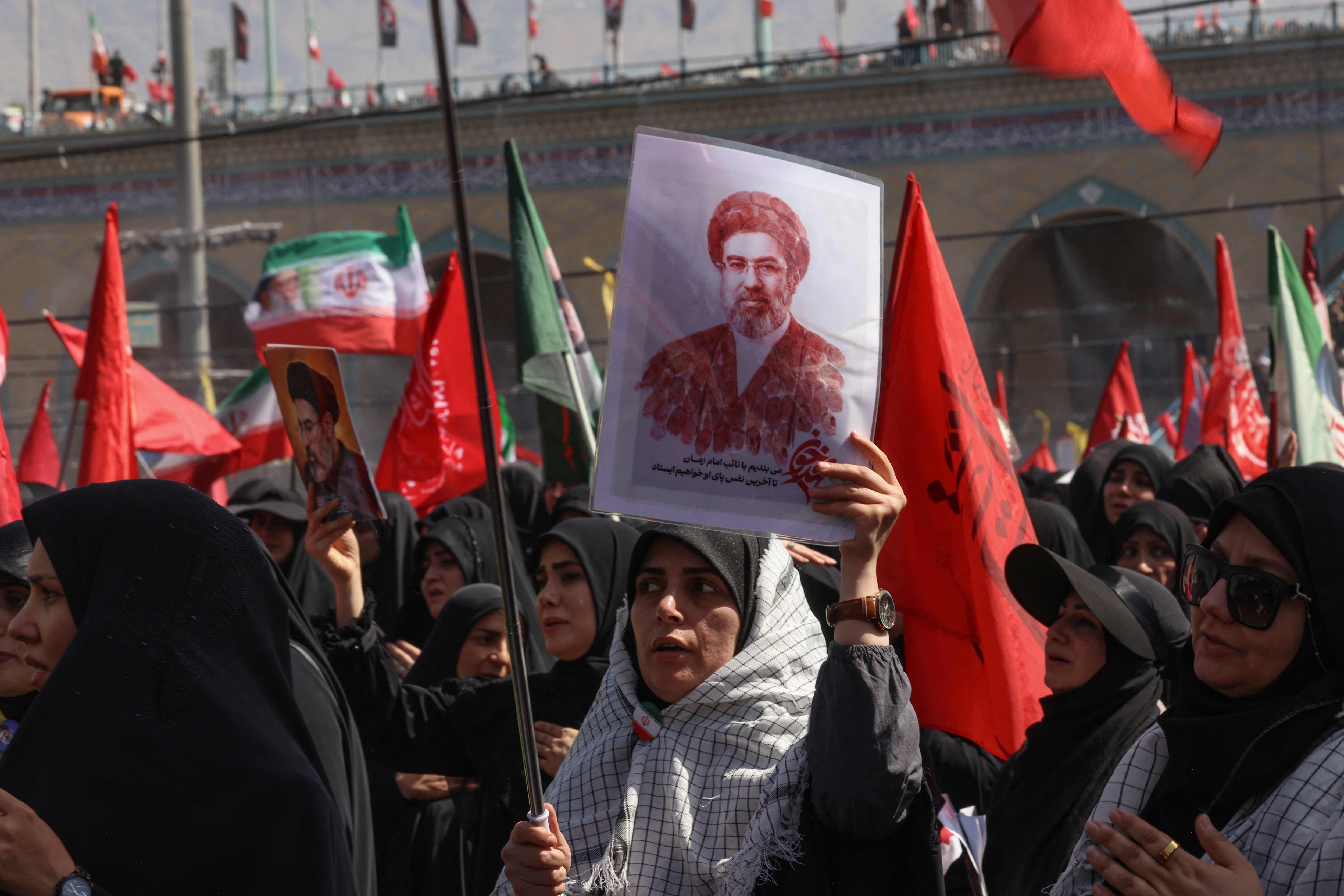A mourner carries a portrait of Iran's supreme leader Mojtaba Khamenei, at the Grand Mosalla where people gathered to pray for Iran's slain supreme leader Ali Khamenei during the second day of funeral ceremonies at the Grand Mosalla in Tehran on July 5, 2026. Prayers were held July 5 over the casket of Iran's late supreme leader Ali Khamenei, the second day of funeral ceremonies that have drawn huge crowds to pay their final respects in Tehran. Khamenei ruled the Islamic republic from 1989 until he was killed aged 86 in an airstrike on the first day of the US-Israeli war with Iran on February 28. (Photo by ATTA KENARE / AFP) /  (AFP)