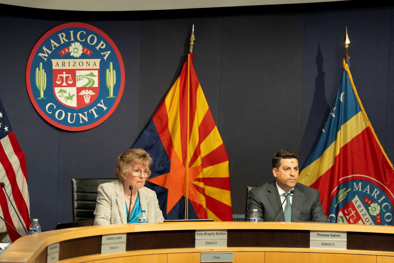 Maricopa County supervisors including Thomas Galvin, in gray suit, listening as Heap was questioned at a special meeting in February.