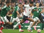 England's Jude Bellingham runs past Mexico's midfielders during their Round of 16 match. (AFP)