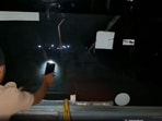 While the driver steers the bus, the conductor is seen using the torchlight of a mobile phone to illuminate the road ahead.