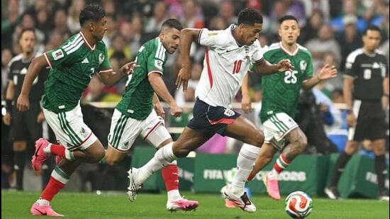 England's Jude Bellingham runs past Mexico's midfielders during their Round of 16 match. (AFP)