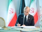 Pakistan's Prime Minister Shehbaz Sharif writing in the condolence book during the state funeral of Iran's late Supreme Leader Ayatollah Ali Khamenei in Tehran. 