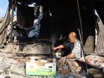 A displaced Palestinian man tends a makeshift oven inside a shelter near the al-Shati refugee camp, west of Gaza City.