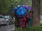  Women cover themselves during rainfall, at Connaught Place, in New Delhi, Tuesday, July 7, 2026. 