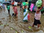 People in Mumbai were seen carrying belongings through water after heavy rainfall in the area.