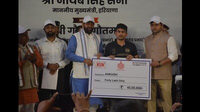 Haryana CM Nayab Singh Saini presents a cash award to an athlete during the event in Panchkula on Tuesday. (Sant Arora/HT) Haryana CM Nayab Singh Saini presents a cash award to an athlete during the event in Panchkula on Tuesday. (Sant Arora/HT)