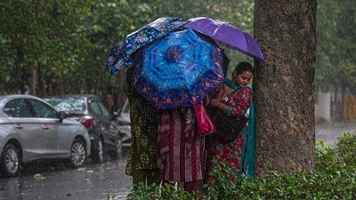 Women cover themselves during rainfall, at Connaught Place, in New Delhi, Tuesday, July 7, 2026. (PTI) Women cover themselves during rainfall, at Connaught Place, in New Delhi, Tuesday, July 7, 2026. (PTI)