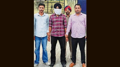 The accused (his face covered) in the custody of Punjab Vigilance Bureau officials in Ludhiana on Tuesday. (HT Photo)