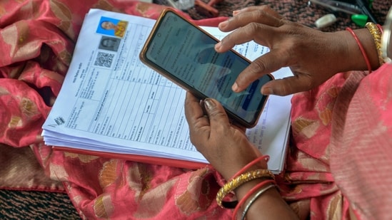 A Booth Level Officer (BLO) verifies voter details during the Special Intensive Revision (SIR) of electoral rolls. (PTI Photo)