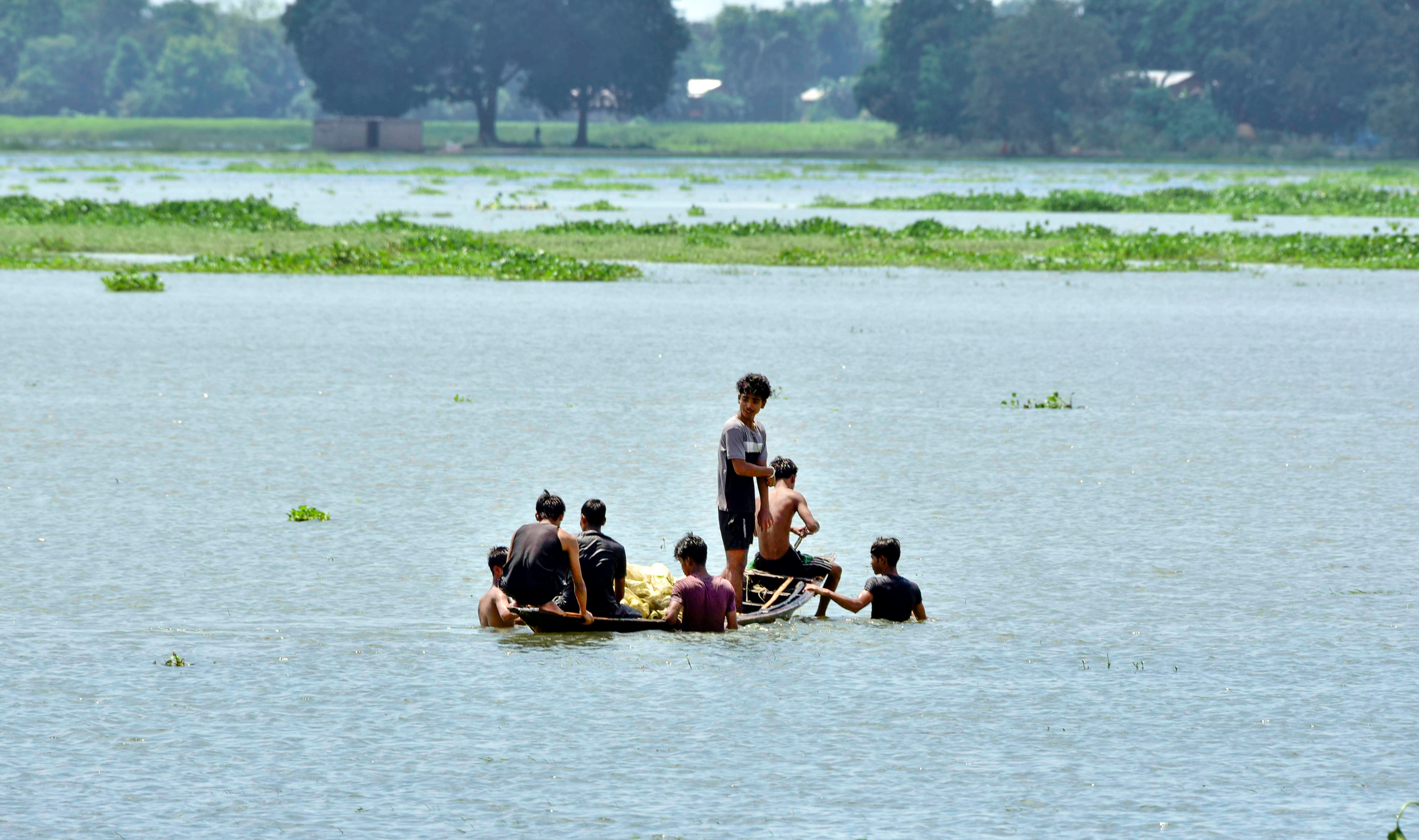 Villagers use a wooden country boat to cross floodwaters in a submerged area at Jhargaon, in Morigaon, Assam. (ANI) Villagers use a wooden country boat to cross floodwaters in a submerged area at Jhargaon, in Morigaon, Assam. (ANI)